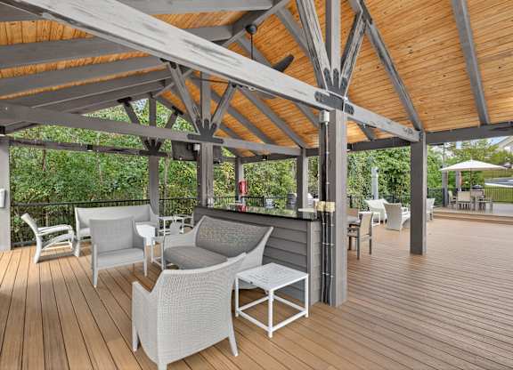 A wooden deck with white chairs and a table.