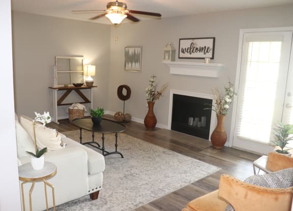 a living room with a white couch and a fireplace  at Laurelwood Apartment Homes, Laurel, MS, 39440