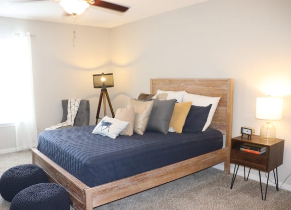 a bedroom with a bed and a ceiling fan  at Laurelwood Apartment Homes, Laurel, Mississippi