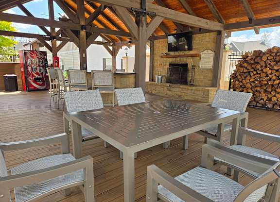 A wooden table surrounded by chairs on a deck.