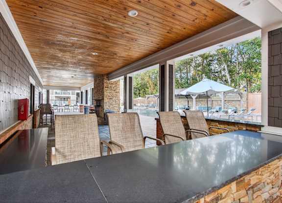 A wooden deck with a table and chairs overlooking a backyard.