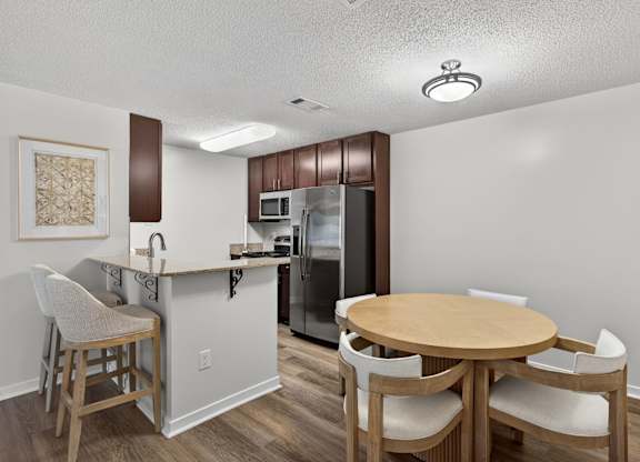 A kitchen with a table and chairs.