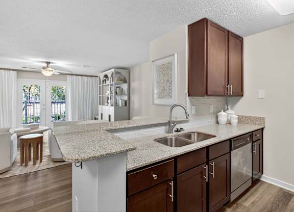 A kitchen with brown cabinets and a granite countertop.