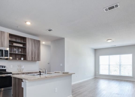 A kitchen with a white counter and wooden cabinets at The Met Apartment Homes, Hattiesburg, MS