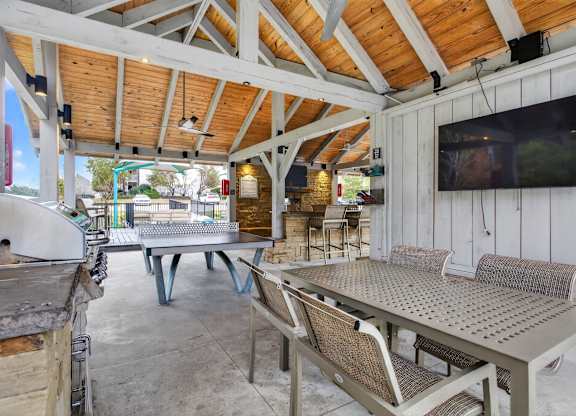 A white wooden patio with a TV on the wall.