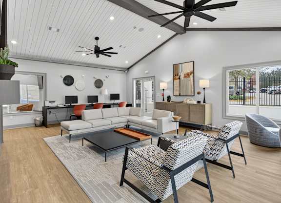 A modern living room with a white ceiling and a glass coffee table.