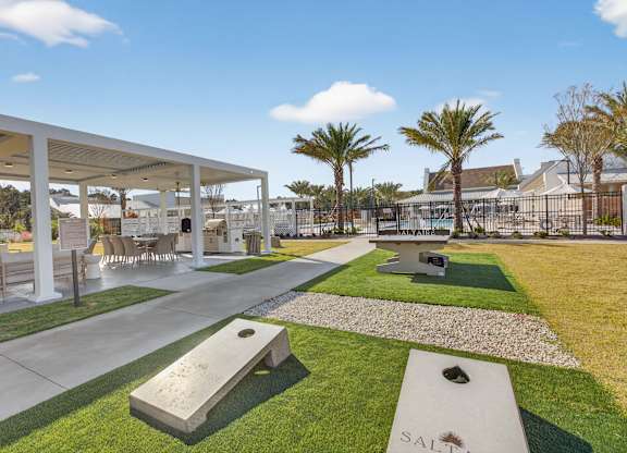 A park with a bench and a pathway leading to a building at Saltaire Apartment Homes in Santa Rosa Beach, FL