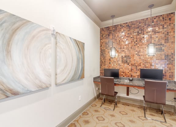 a home office with two computers and a large painting on the wall at Cumberland Place Apartment Homes, Tyler, TX 75703