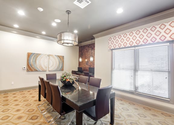 a dining room with a table and chairs and a large window at Cumberland Place Apartment Homes, Tyler, TX