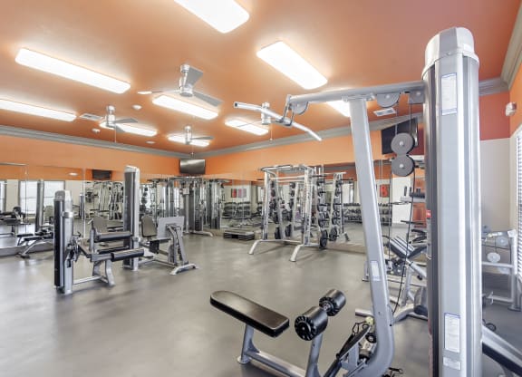 a gym with weights and cardio equipment in a building at Cumberland Place Apartment Homes, Tyler, Texas
