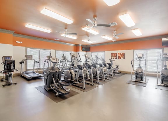 a gym with a row of exercise bikes in it at Cumberland Place Apartment Homes, Tyler, TX
