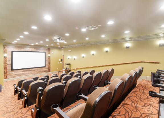 a conference room with a projector screen and chairs at Cumberland Place Apartment Homes, Texas