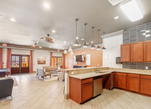 a clubhouse with a kitchen and a living room with a table and chairs at Cumberland Place Apartment Homes, Texas 75703
