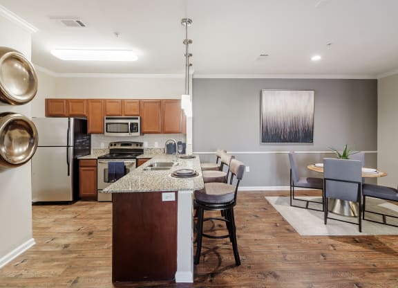 a kitchen and dining room area with a table and chairs at Cumberland Place Apartment Homes, Tyler, Texas