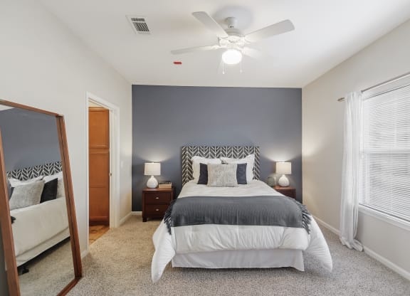 a bedroom with a bed and a ceiling fan at Cumberland Place Apartment Homes, Texas 75703