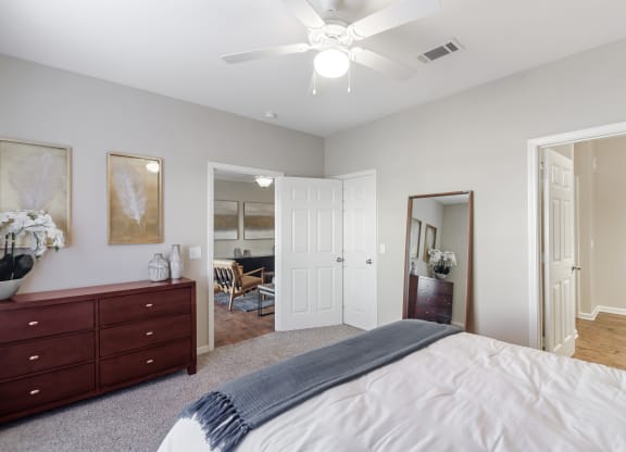 a bedroom with a large bed and a ceiling fan at Cumberland Place Apartment Homes, Tyler 75703