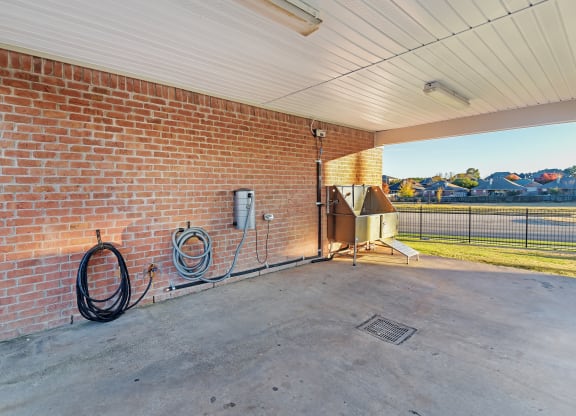 the back patio of a brick building with a water heater and a grill at Cumberland Place Apartment Homes, Tyler, TX 75703