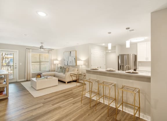 a living room with a kitchen and a couch and chairs at The Azul Apartment Homes in Oxford, 38655