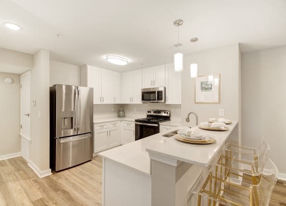 a kitchen with a large island and stainless steel refrigerator at The Azul Apartment Homes in MS 38655
