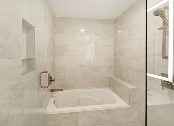 the ensuite bathroom has a tub and a shower at The Azul Apartment Homes in Oxford, MS 38655