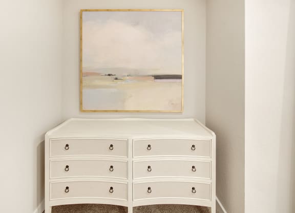 a white dresser with a painting on the wall above it at The Azul Apartment Homes in Oxford, Mississippi 38655