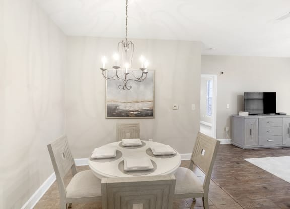 Dining room with a table and chairs and a chandelier at Highlands Apartment Homes, Bartlett, TN