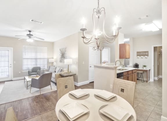 Living room with a dining room table and a kitchen at Highlands Apartment Homes, Bartlett, TN
