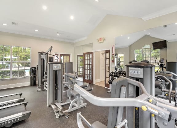 Gym with weights and cardio equipment in a building with windows at Highlands Apartment Homes, Bartlett, TN, 38135
