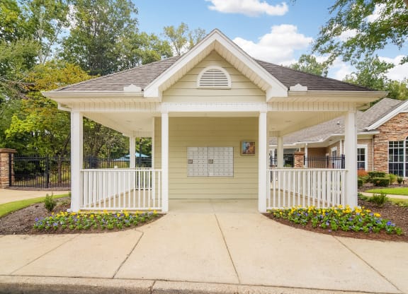 Front porch of a yellow house with a porch swing at Highlands Apartment Homes, Tennessee , 38135