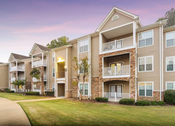 Outlook of a building at dusk with green grass at Highlands Apartment Homes, Bartlett, TN, Tennessee , 38135