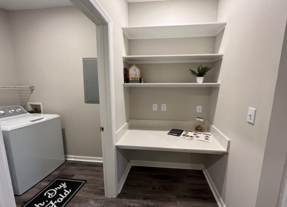a utility room with shelves and a sink and a washer and dryer at Carlton Park Apartment Homes, Flowood, MS, 39232