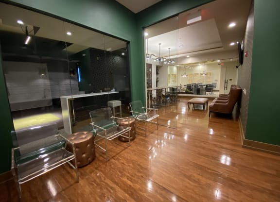 a large lobby with chairs and tables and a large window at The Retreat Apartment Homes in Williston, 58801