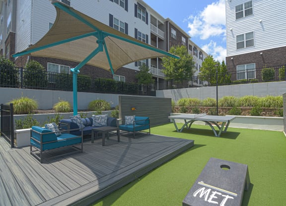 a rendering of a patio with furniture and a picnic table at The Met Apartment Homes, Mississippi