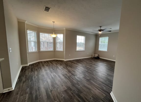 an empty living room with wood floors and a ceiling fan at Carlton Park Apartment Homes, Flowood