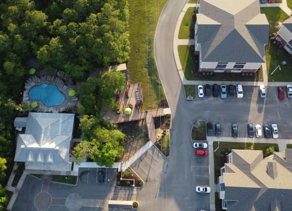 a birds eye view of a parking lot with a pool and trees at Lagniappe of Biloxi Apartment Homes, Biloxi, MS, Mississippi   , 39532