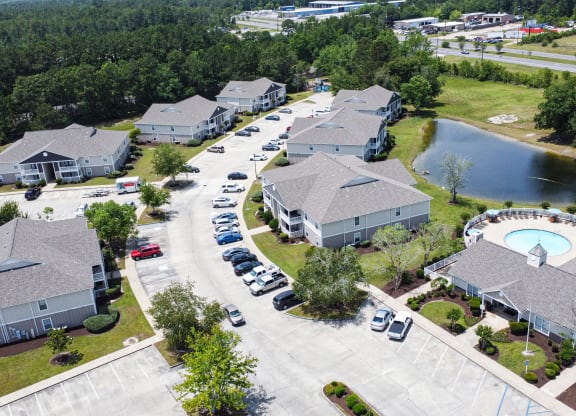 an aerial view of a neighborhood of houses and a swimming pool at The Pointe Apartment Homes in MS 39553
