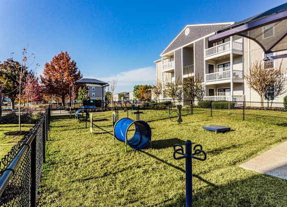 A playground with a slide and a climbing frame is in front of a building  at Gulf Hills Apartment Homes in Ocean Springs, 39564
