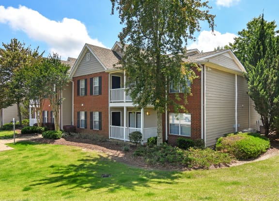 an apartment building with grass and trees in front of it at Bridgewater Apartment Homes, Mississippi