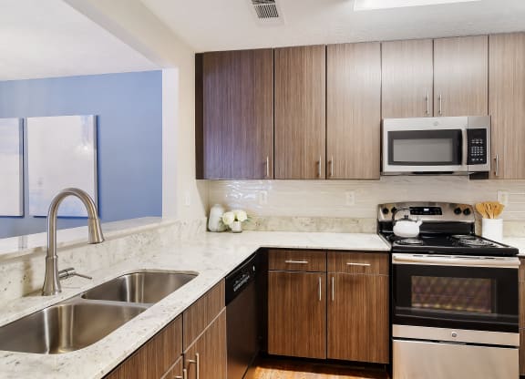 a modern kitchen with granite counter tops and wooden cabinets at Bridgewater Apartment Homes, Brandon, MS