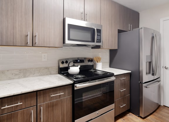 a kitchen with stainless steel appliances and wooden cabinets at Bridgewater Apartment Homes, Brandon, Mississippi