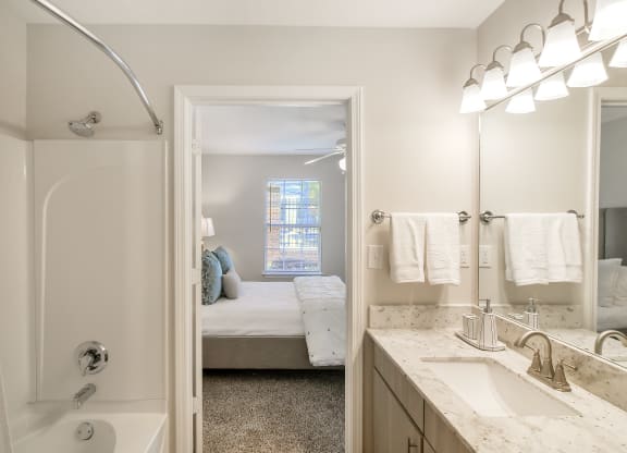 a bathroom with a shower and a sink and a mirror at Bridgewater Apartment Homes, Brandon, MS