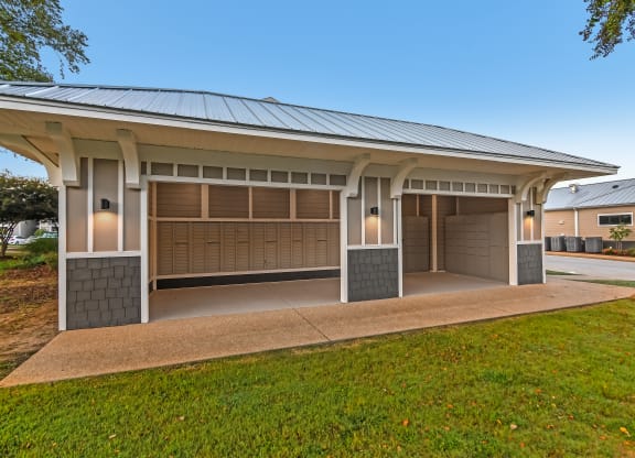 a house with two garage doors and a lawn at Crossgates Apartment Homes, Starkville