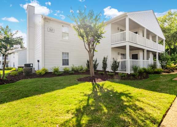 A white two story building with a balcony on the second floor.