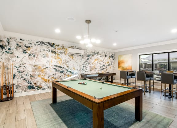 a pool table in a living room with tables and chairs at Crossgates Apartment Homes, Mississippi