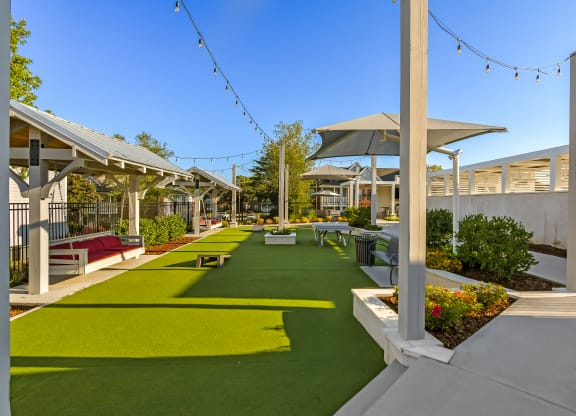 a courtyard with picnic tables and chairs and grass at Crossgates Apartment Homes, Starkville, MS