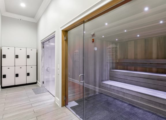 a large elevator lobby with a glass door and a bench in it at Crossgates Apartment Homes, Starkville, 39759