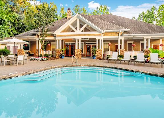 A house with a pool in front of it.