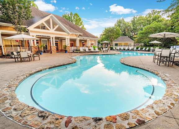 A large swimming pool surrounded by a stone border.