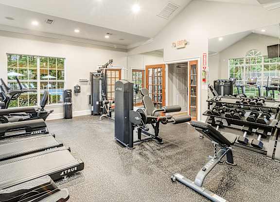 A gym with treadmills, weights, and exercise equipment.