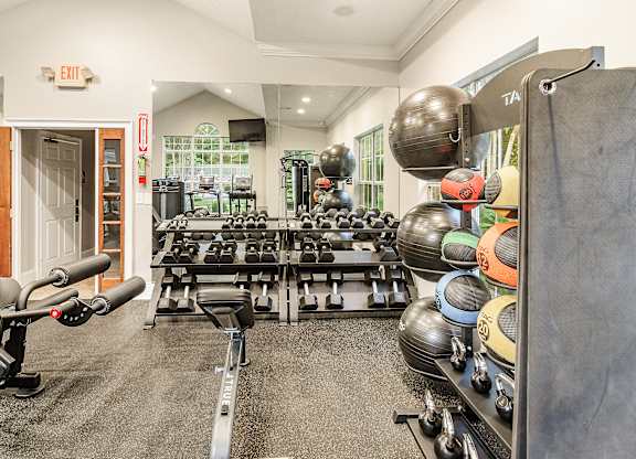 A gym with a variety of equipment including weights and dumbbells.